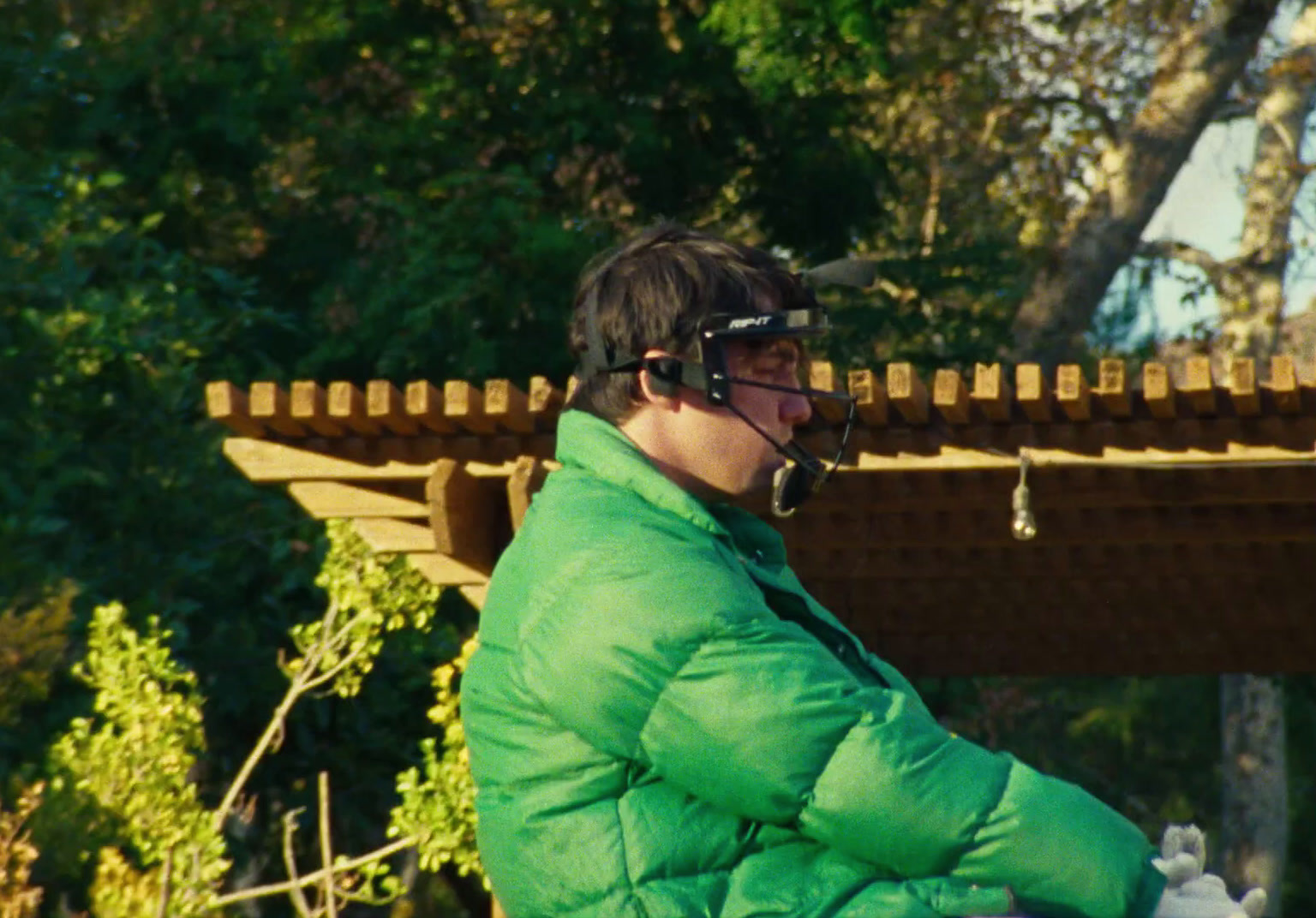 a man in a green jacket sitting on a bench