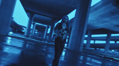 a woman standing in the middle of an empty parking garage