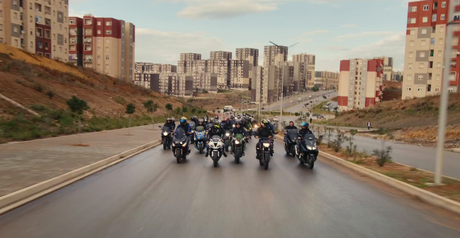 a group of people riding motorcycles down a street