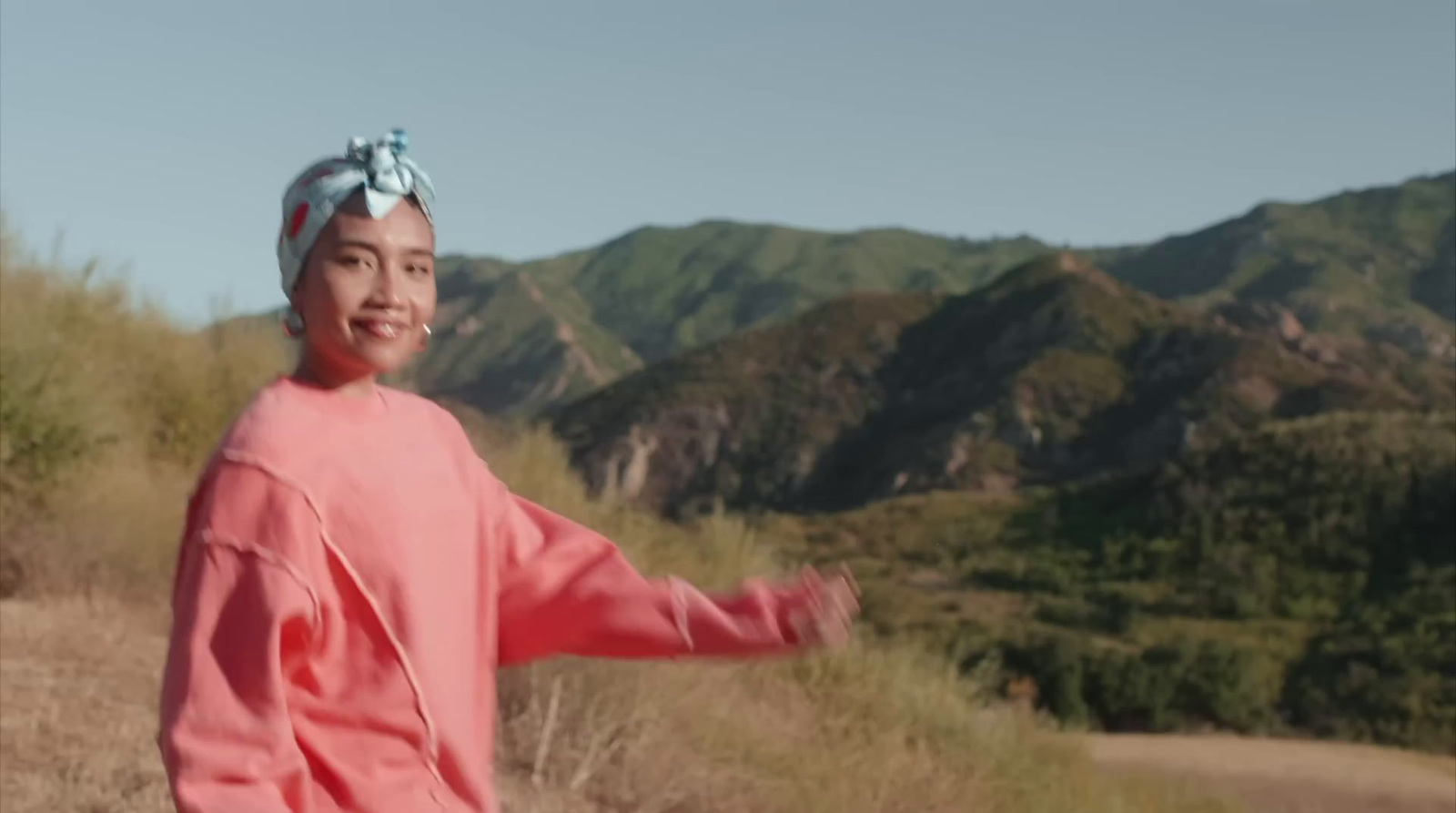 a woman in a pink shirt and a blue head scarf