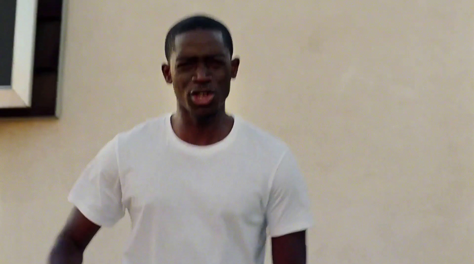 a man in a white t - shirt holding a white frisbee