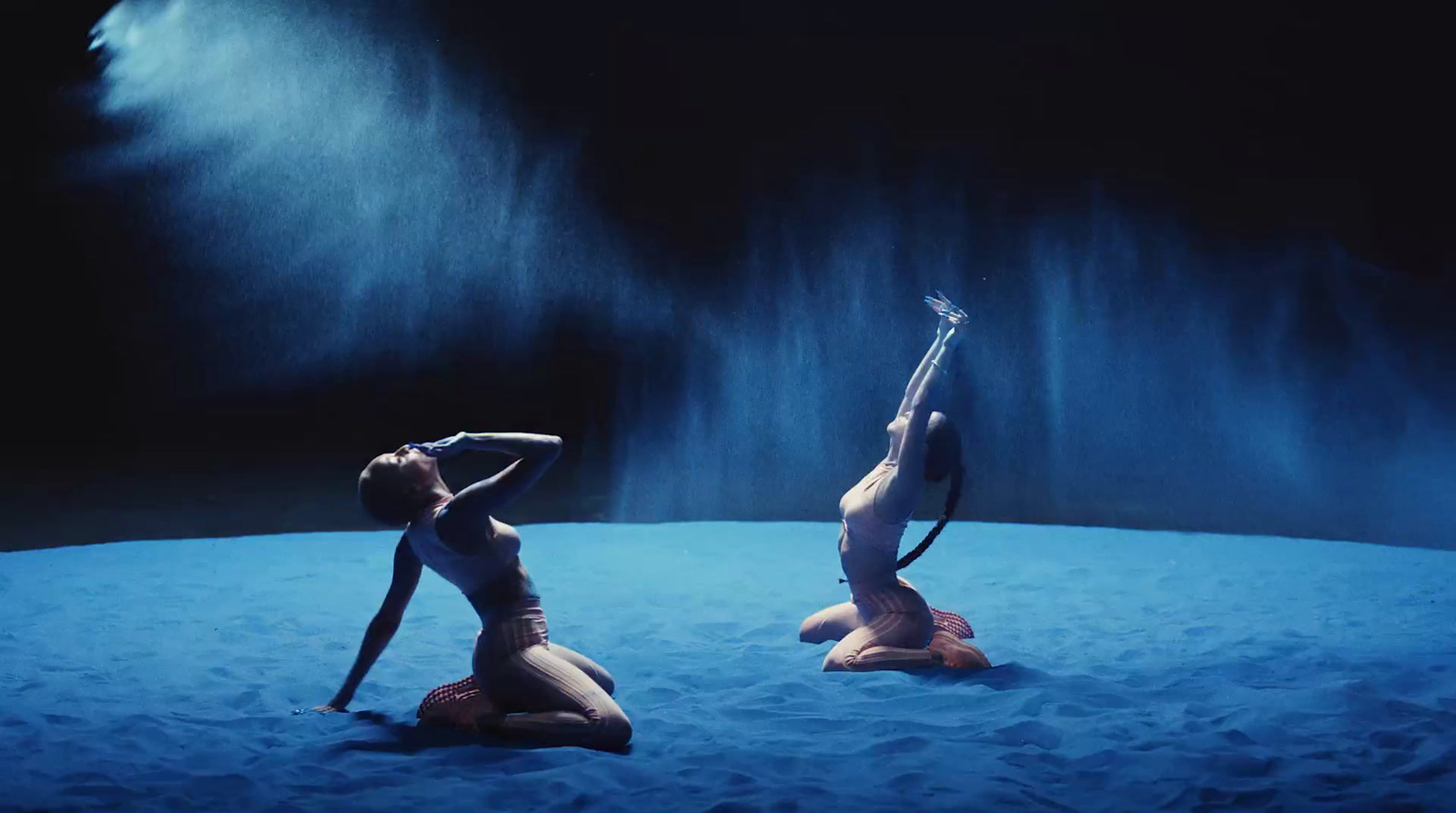 a couple of women in bikinis on a blue surface