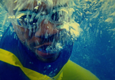 a man in a blue and yellow shirt under water