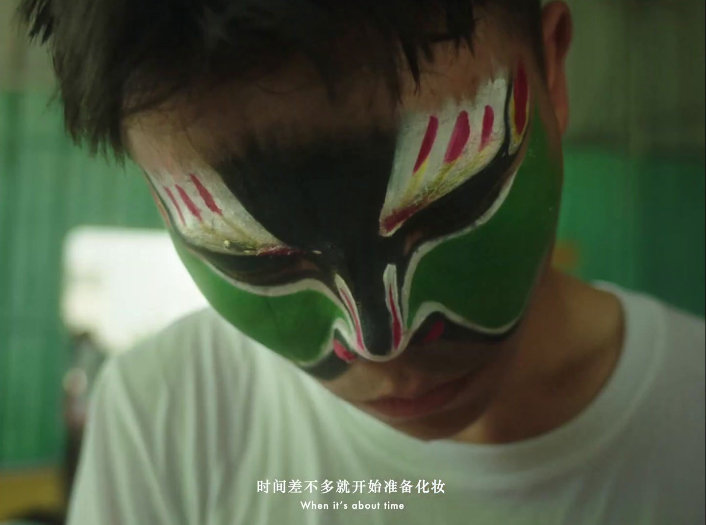 a young man with a painted face looks at his cell phone