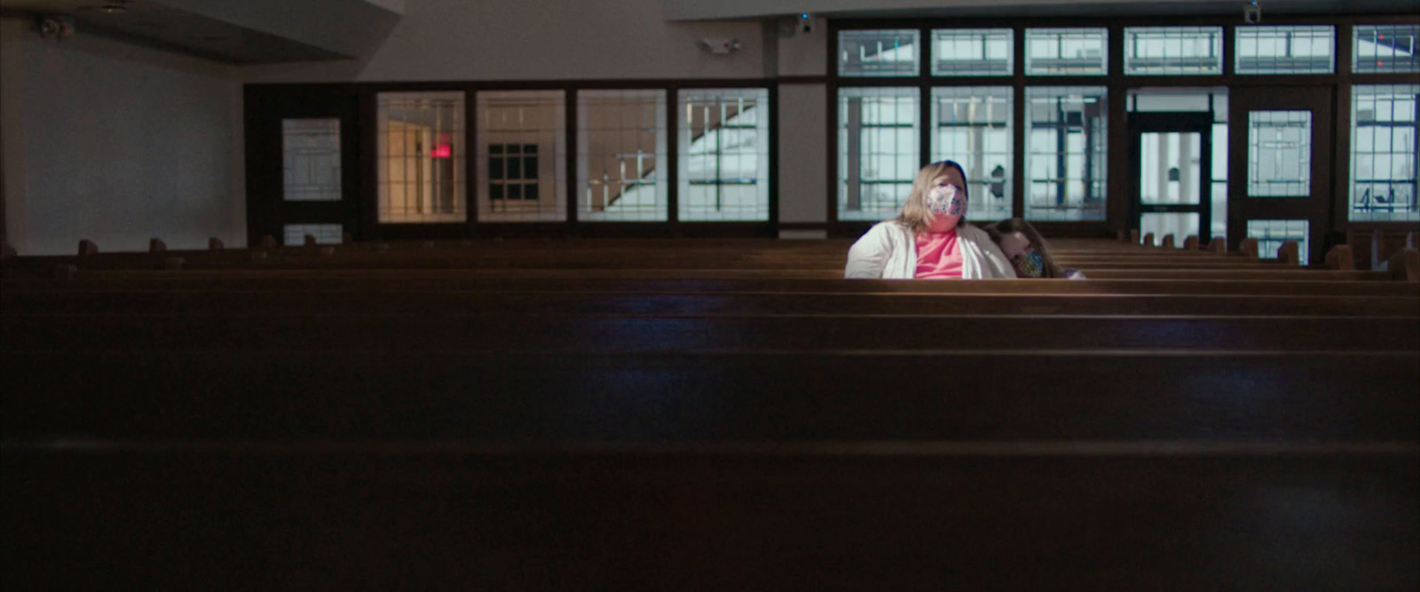 a woman is sitting in a church alone