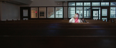 a woman is sitting in a church alone