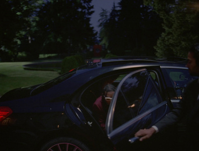 a man in a suit getting out of a car