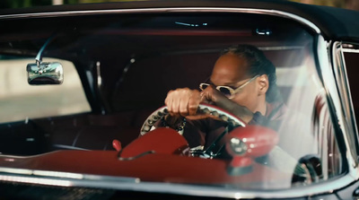 a man driving a red car with sunglasses on