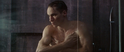 a man in a shower with his hands on his chest