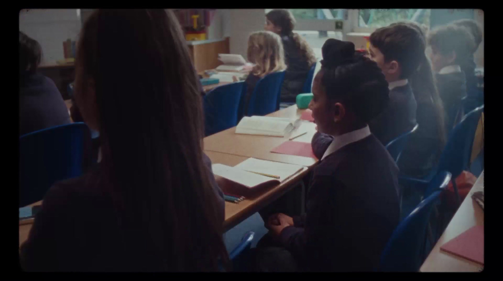 a group of children sitting at a table in a classroom