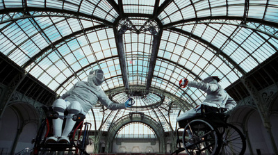 two men in white suits on bicycles in a building