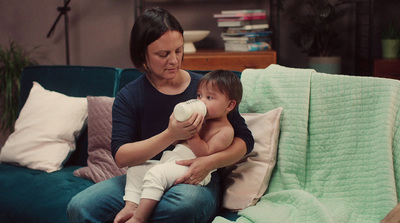 a woman sitting on a couch holding a baby