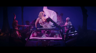 a group of people standing around a car in the dark