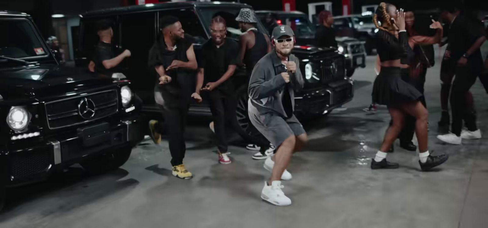 a group of people standing around a black car