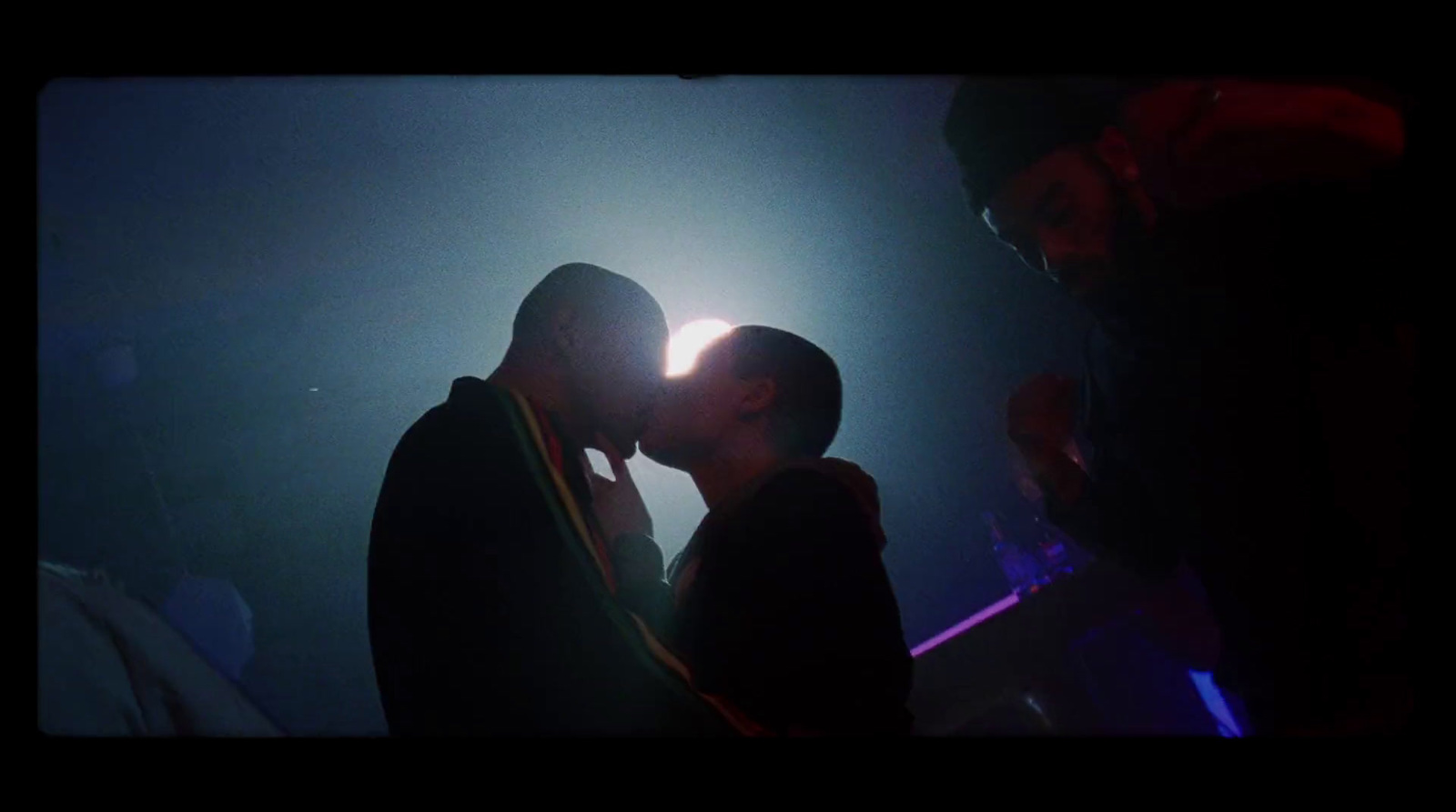 a man and a woman kissing in a dark room