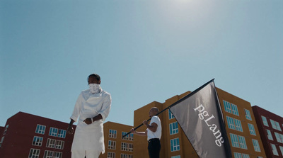 a man standing on a snowboard next to a flag