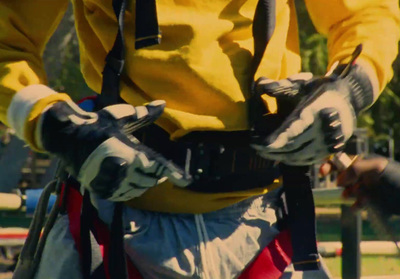 a man in a yellow shirt holding a pair of gloves