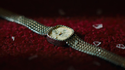 a close up of a watch on a red surface