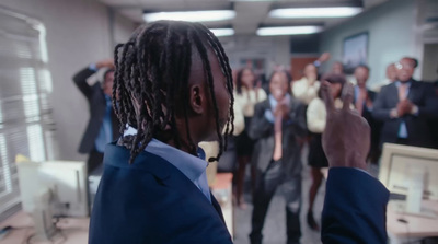 a man with dreadlocks standing in front of a group of people