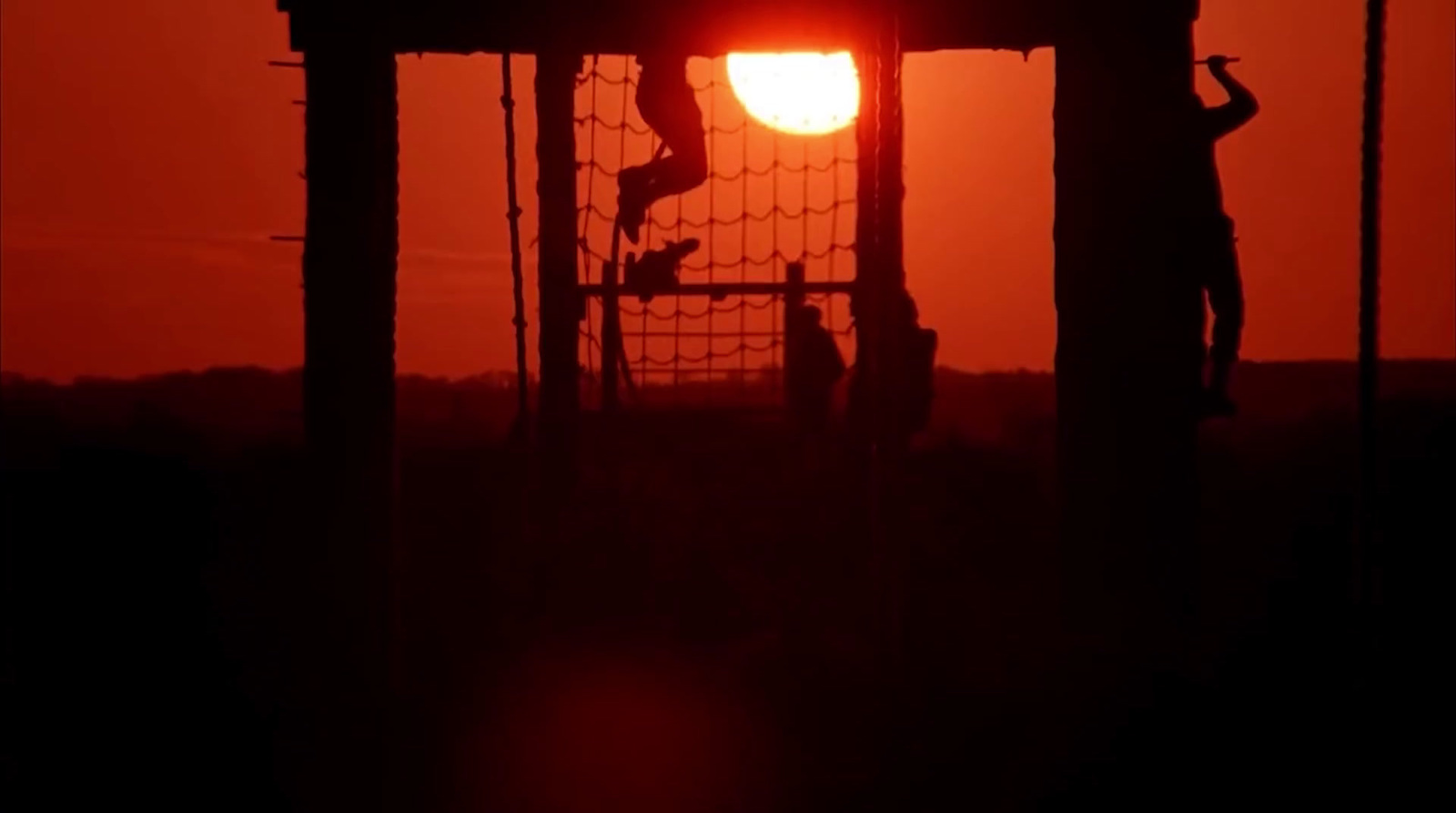 the sun is setting behind a soccer goal