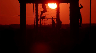 the sun is setting behind a soccer goal