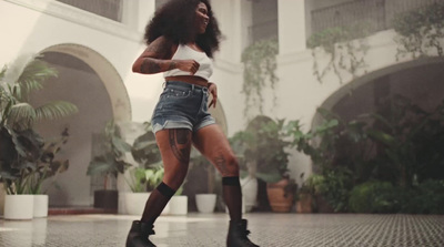 a woman in short shorts and boots is dancing