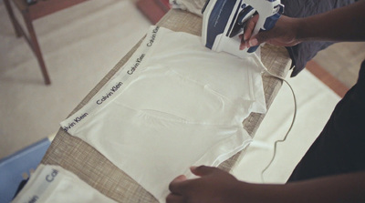 a person ironing a shirt on a table