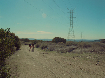 a couple of people walking down a dirt road