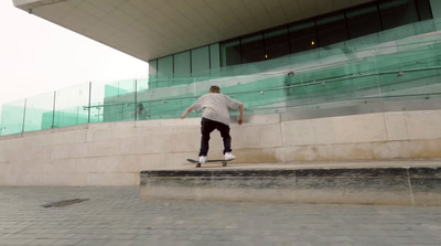 a man riding a skateboard down the side of a stone wall