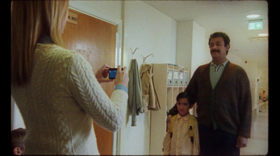 a man taking a picture of a woman and a child