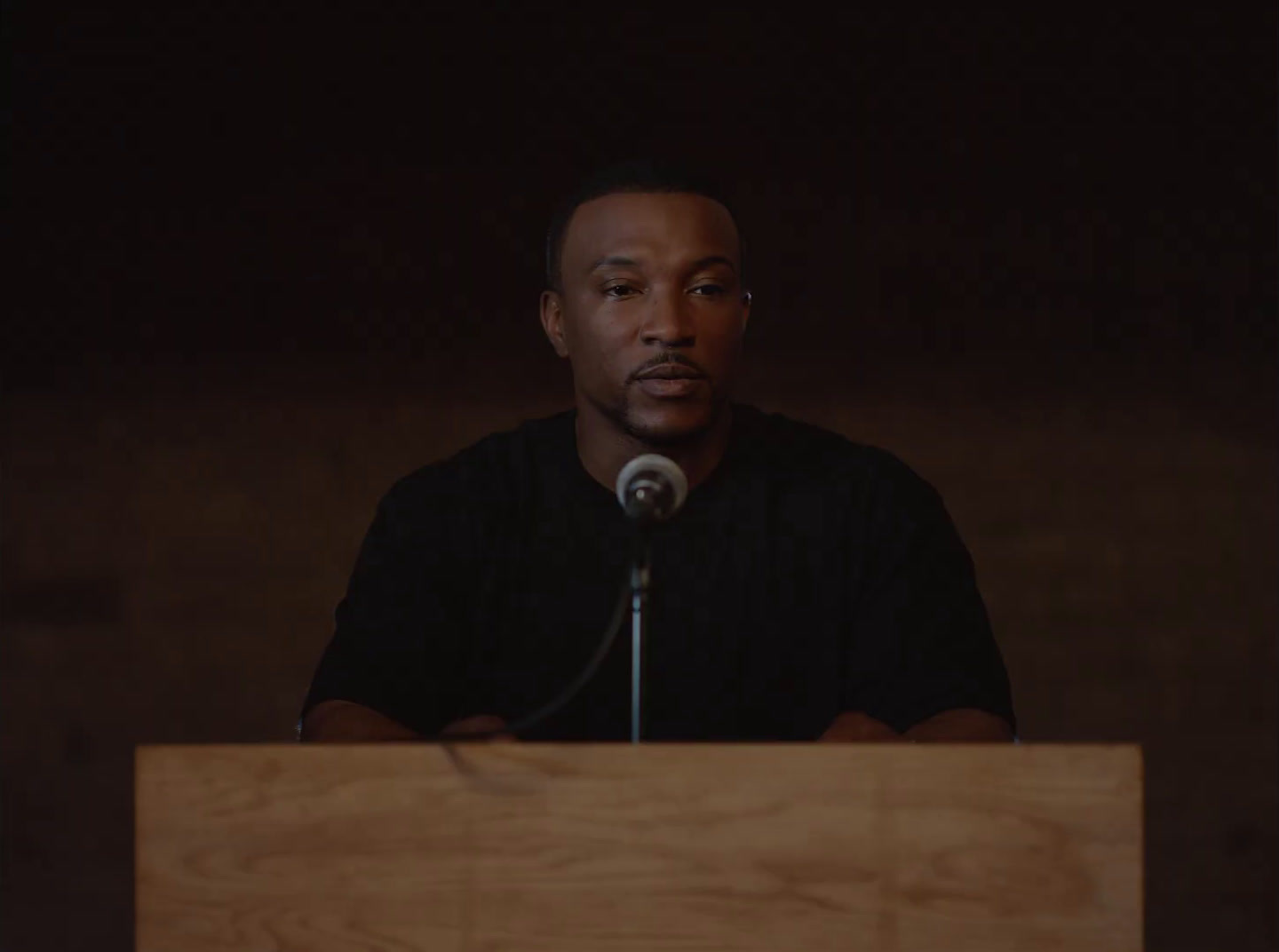 a man standing at a podium in front of a microphone