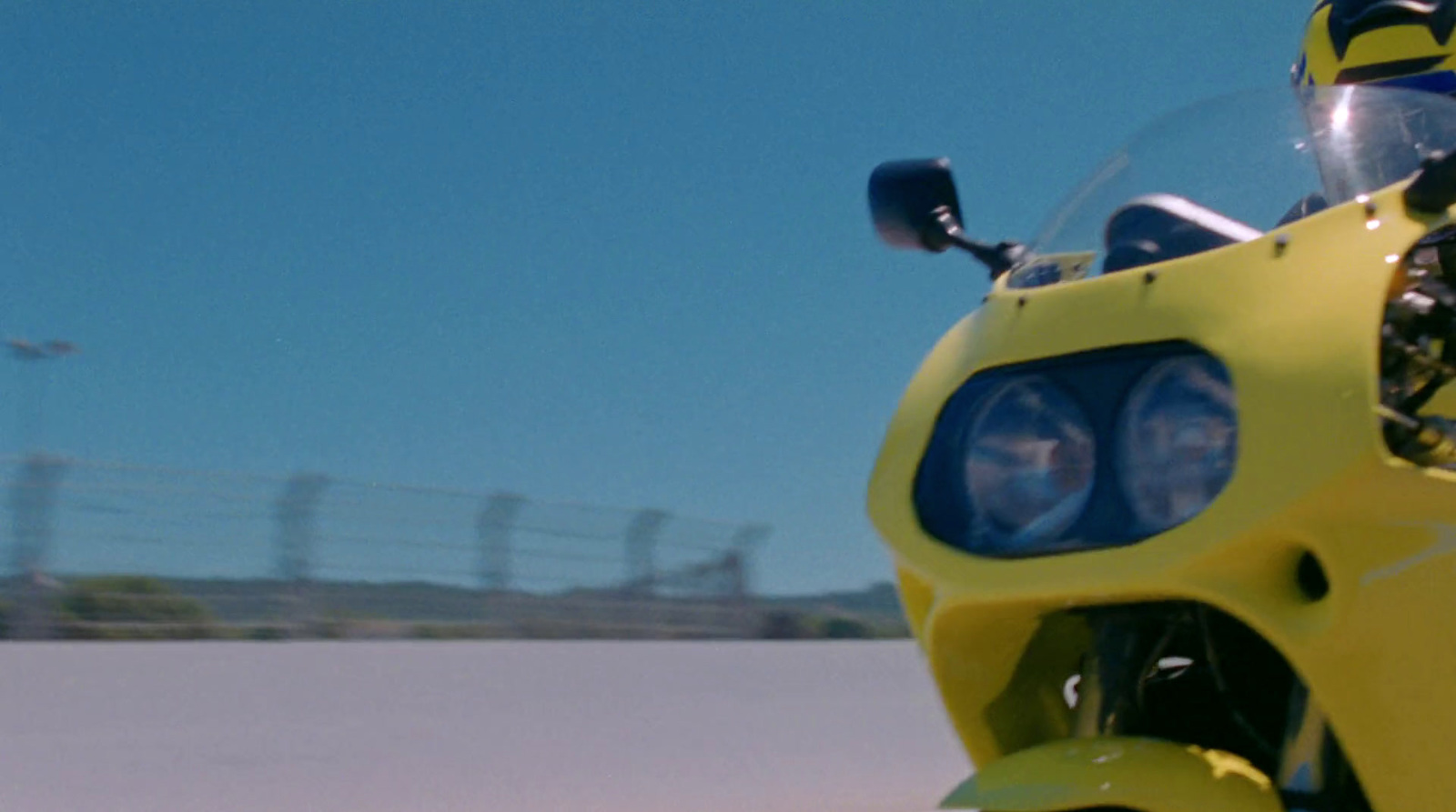 a person riding a yellow motorcycle on a road