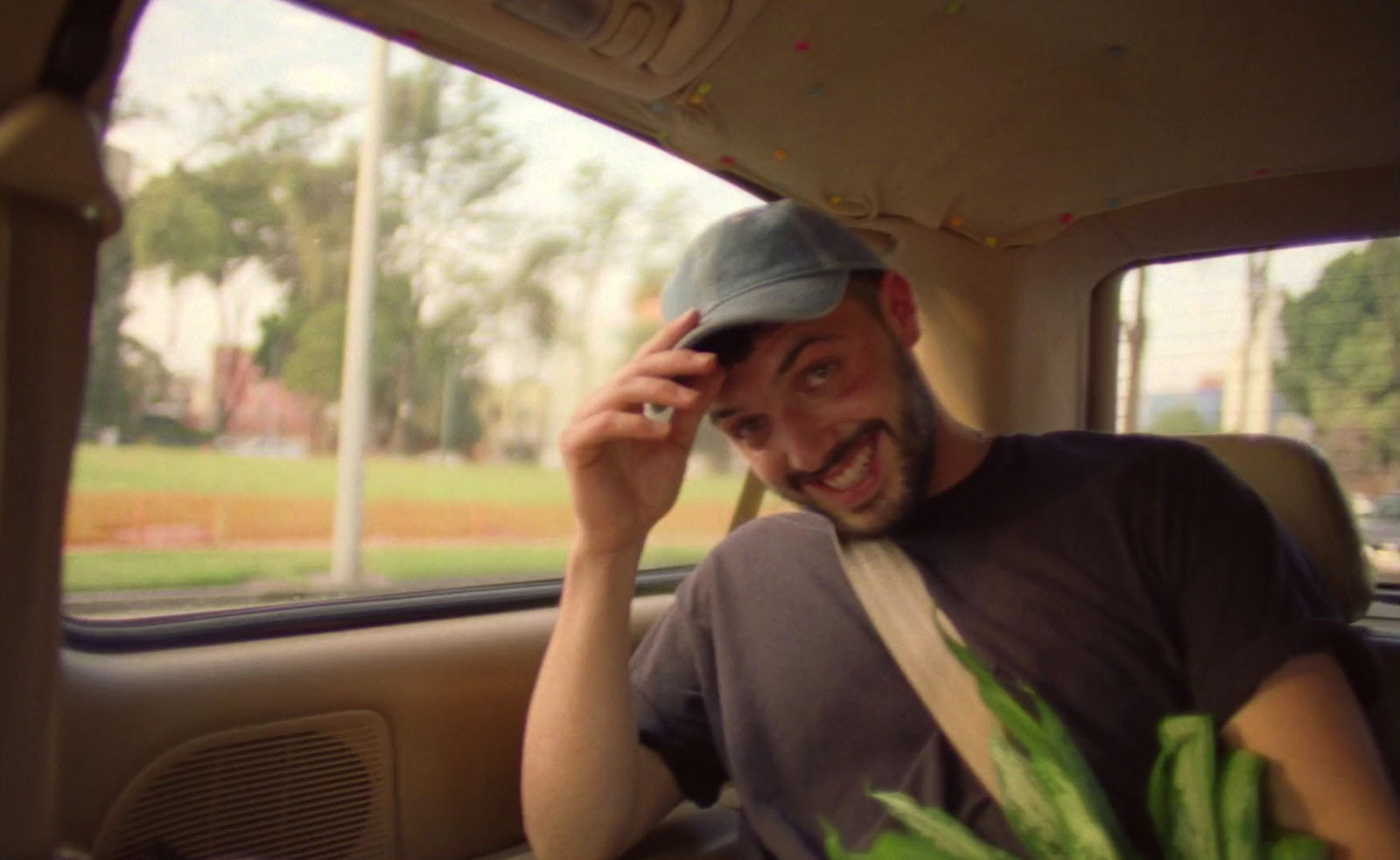 a man sitting in the back of a car talking on a cell phone