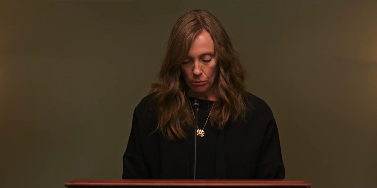 a woman standing at a podium in front of a microphone