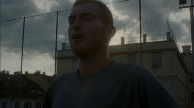 a man is standing in front of a fence