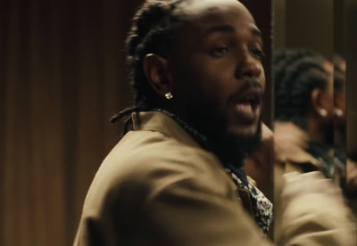 a man with dreadlocks standing in front of a mirror