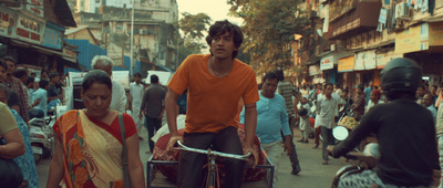 a man riding on the back of a motorcycle down a street