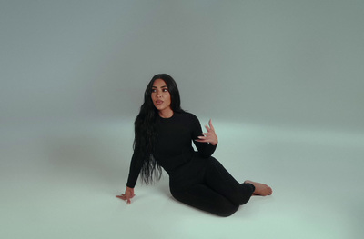 a woman sitting on the floor in a black outfit