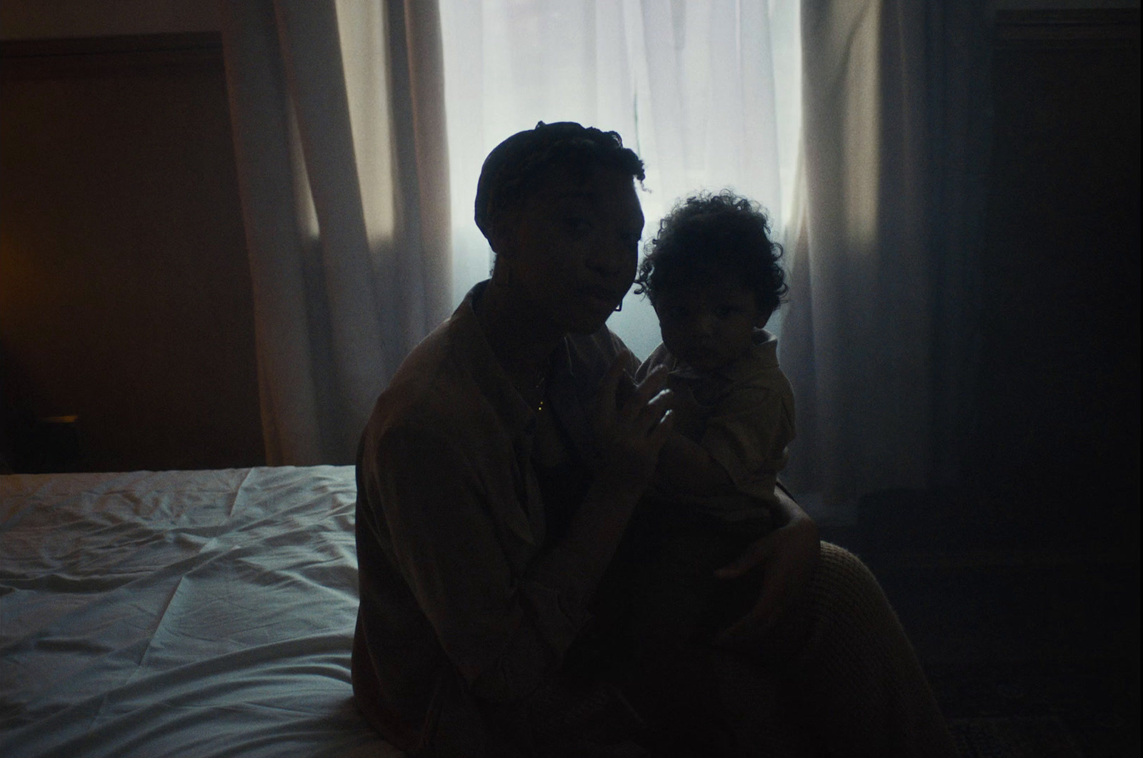 a man and a little girl sitting on a bed