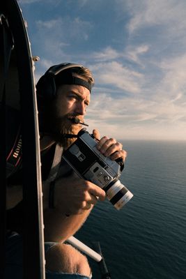 a man holding a camera while sitting on a boat