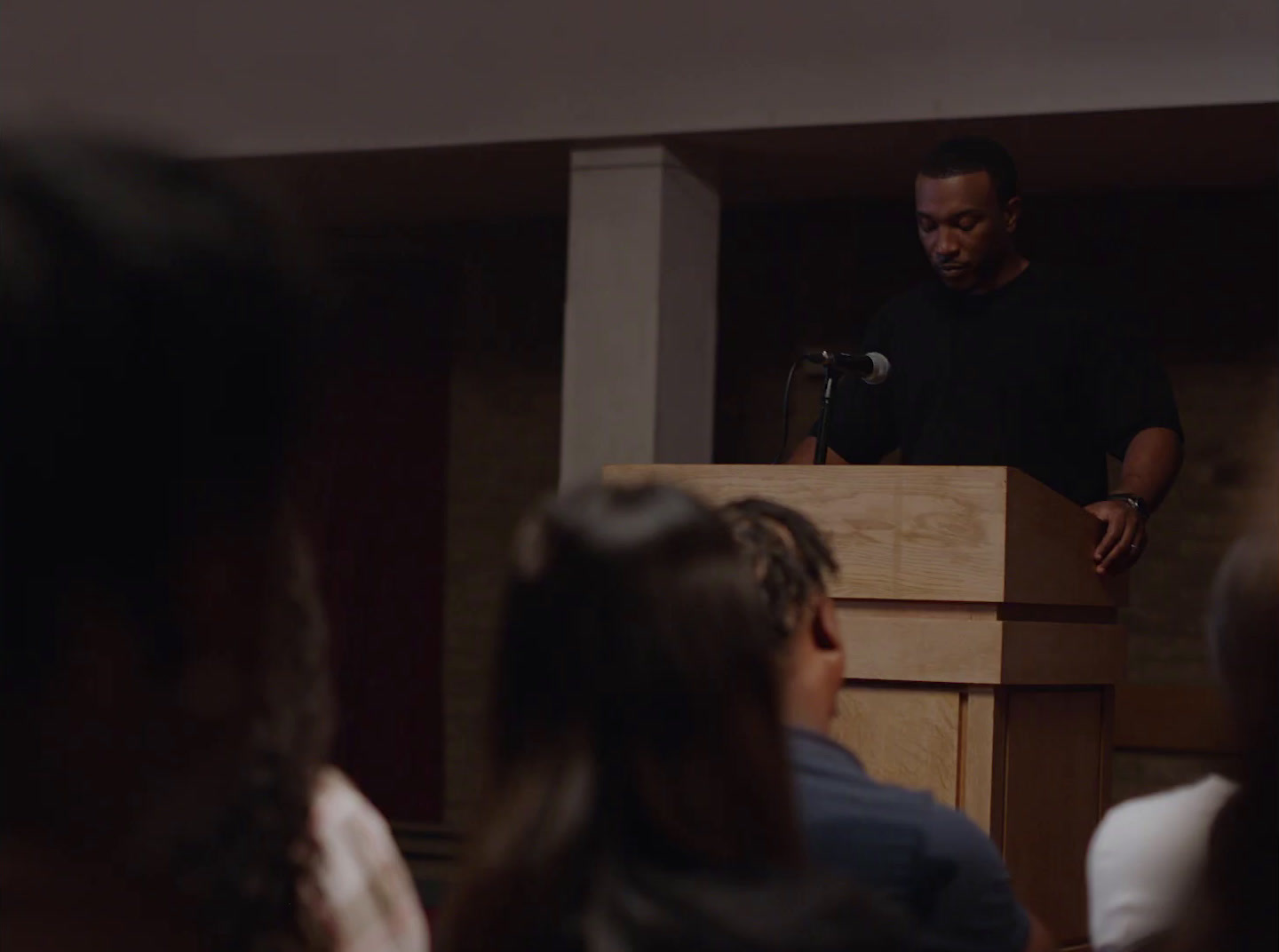 a man standing at a podium in front of a crowd