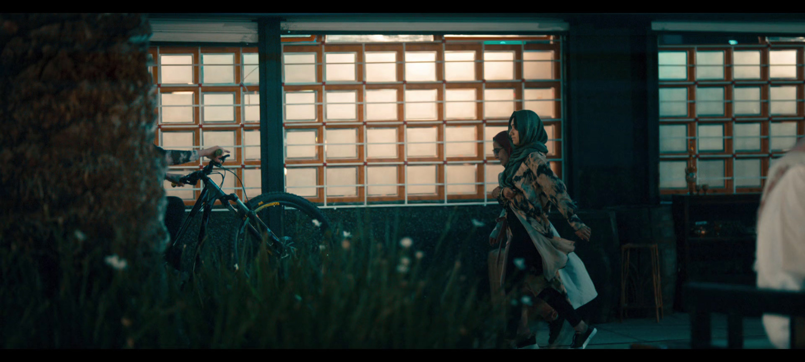 a woman standing next to a bike in front of a building