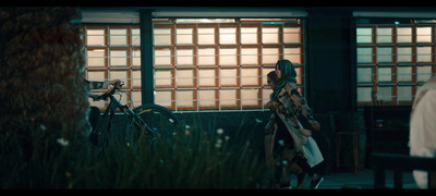 a woman standing next to a bike in front of a building