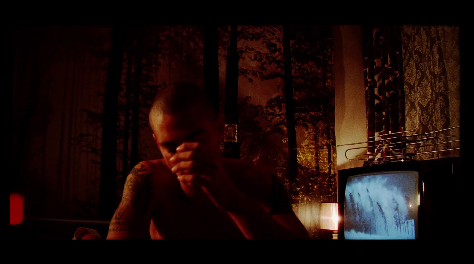 a man sitting in front of a tv in a dark room