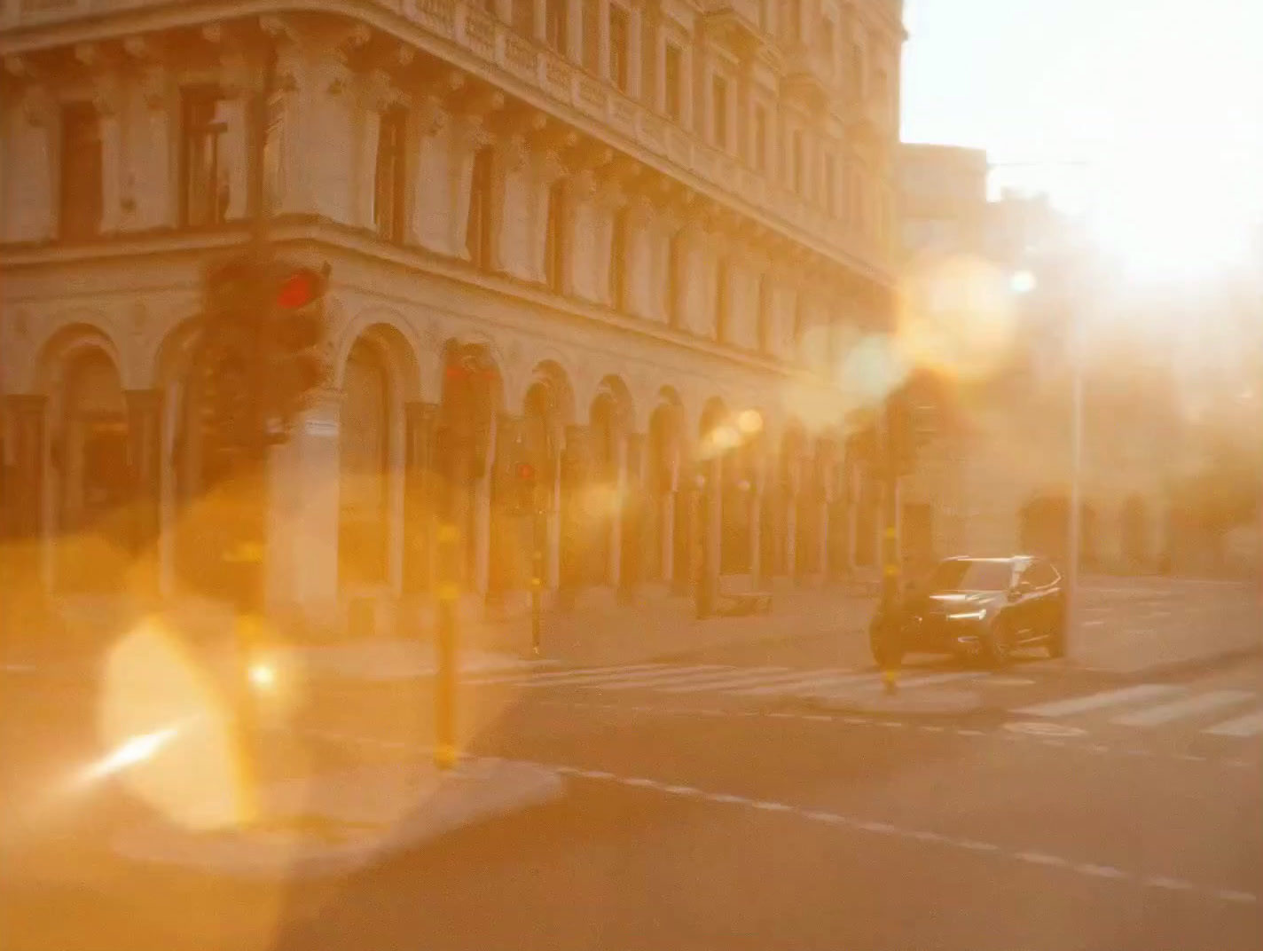 a car driving down a street next to a tall building