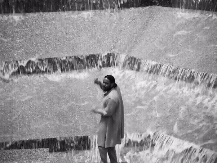 a woman standing in front of a waterfall