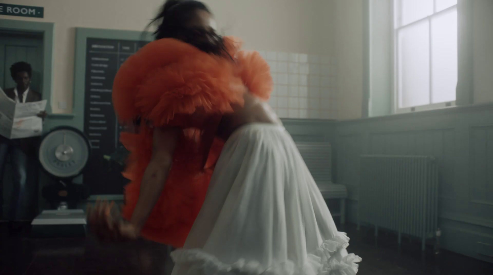 a woman in a white dress standing in a room