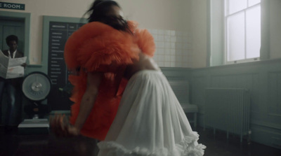 a woman in a white dress standing in a room