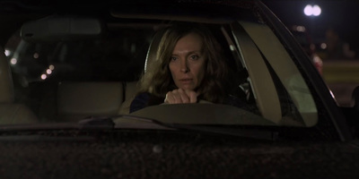 a woman sitting in a car looking out the window