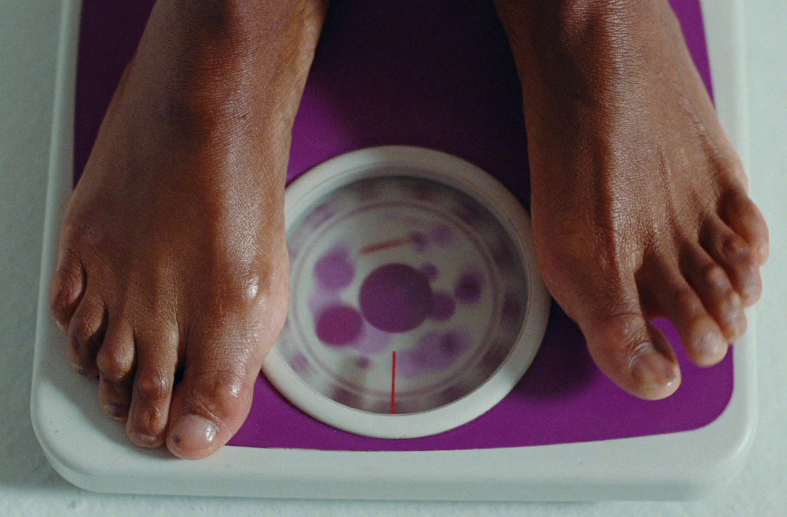 a person standing on a scale with their feet on a bowl